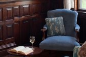 Closeup of Blue chair with book and wine on table