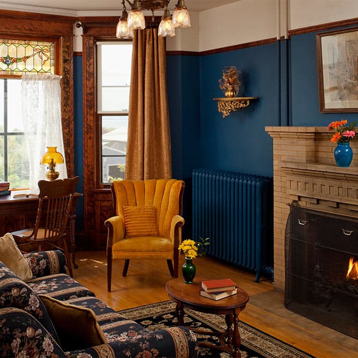 Sitting Room with couch, desk, yellow chair, and fireplace