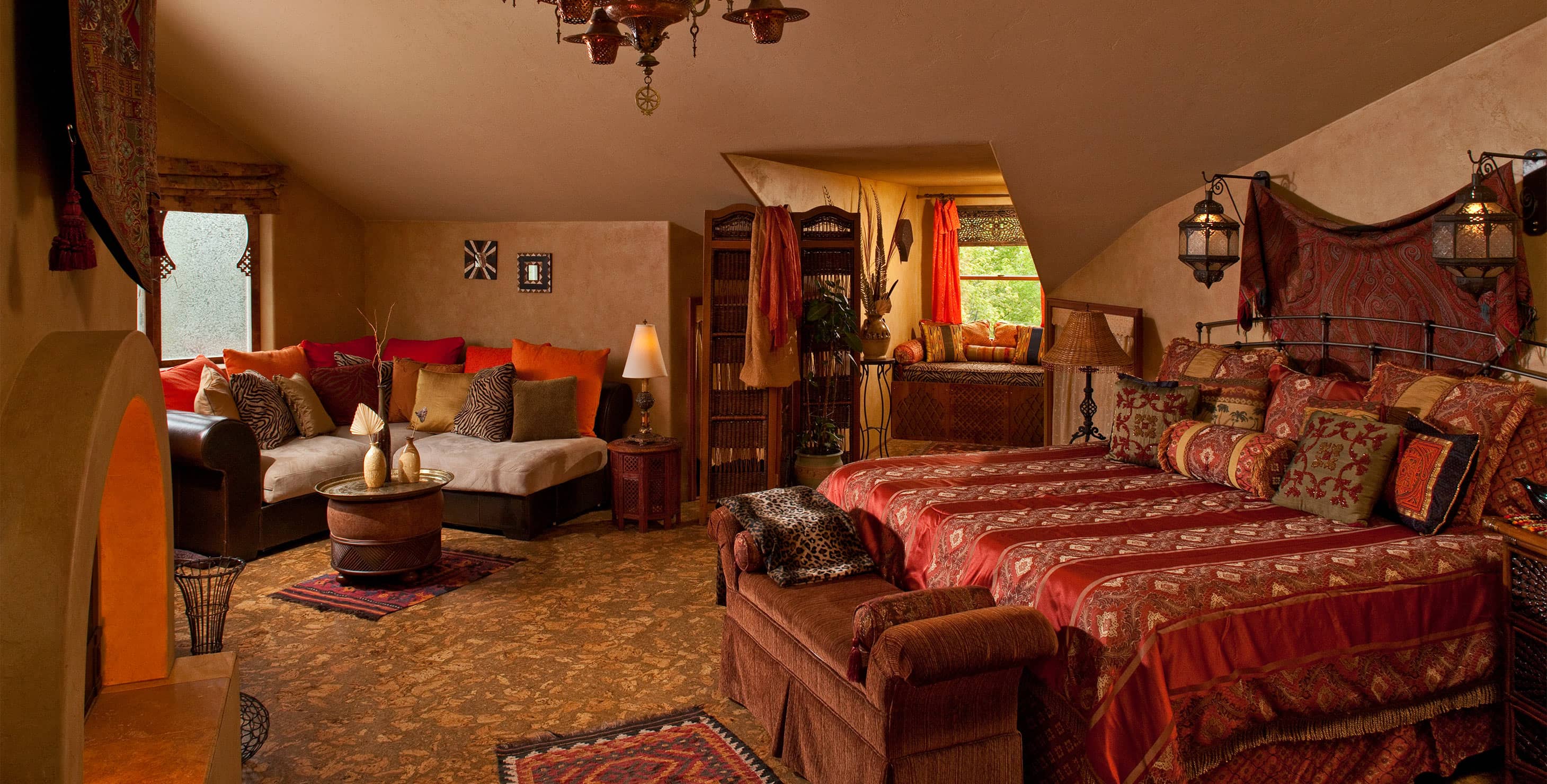 Bed, Window seat, sitting area, and fireplace in Moroccan Suite