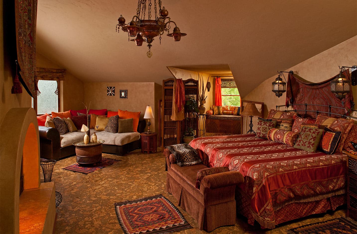 Bed, window seat, sitting area, and fireplace in Moroccan Suite