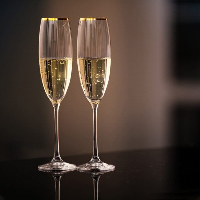 A pair of champagne glasses on a black table