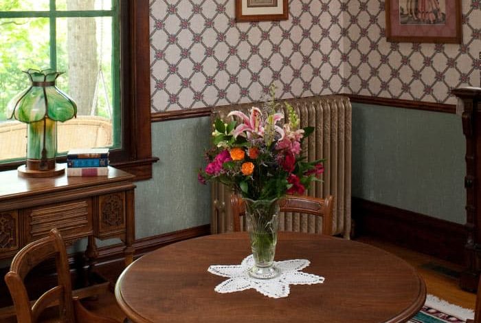 Dining table set with flowers and ornate radiator in background