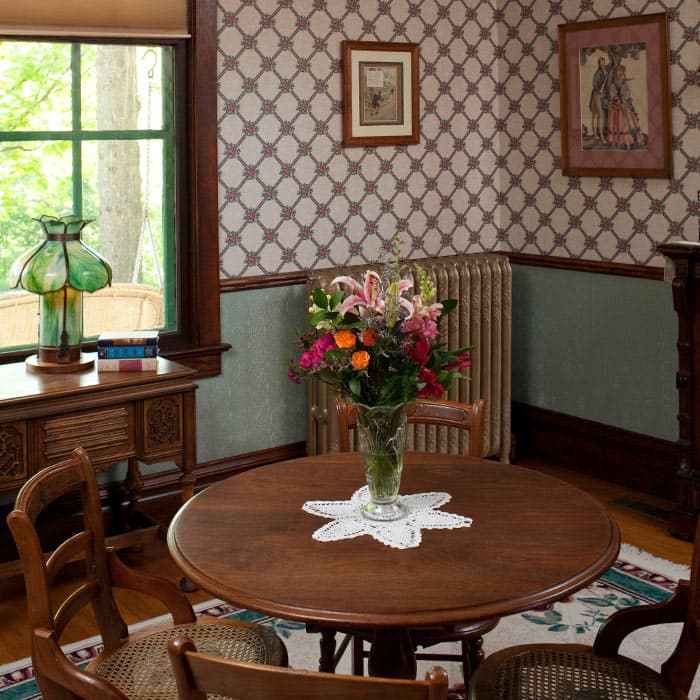 Dining table set with flowers and ornate radiator in background