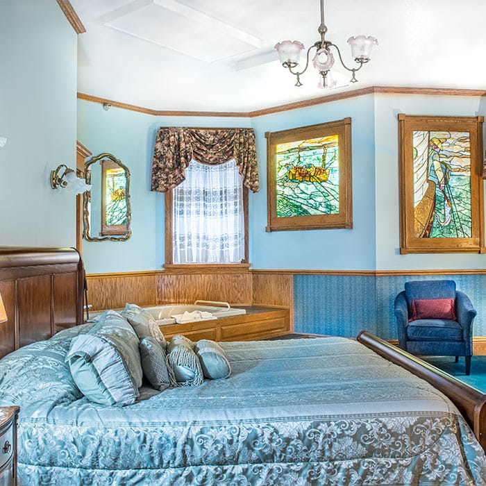 Bed in Room IX with tub and chair in background