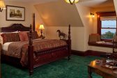 Four poster bed in Suite XI with window seat in distance
