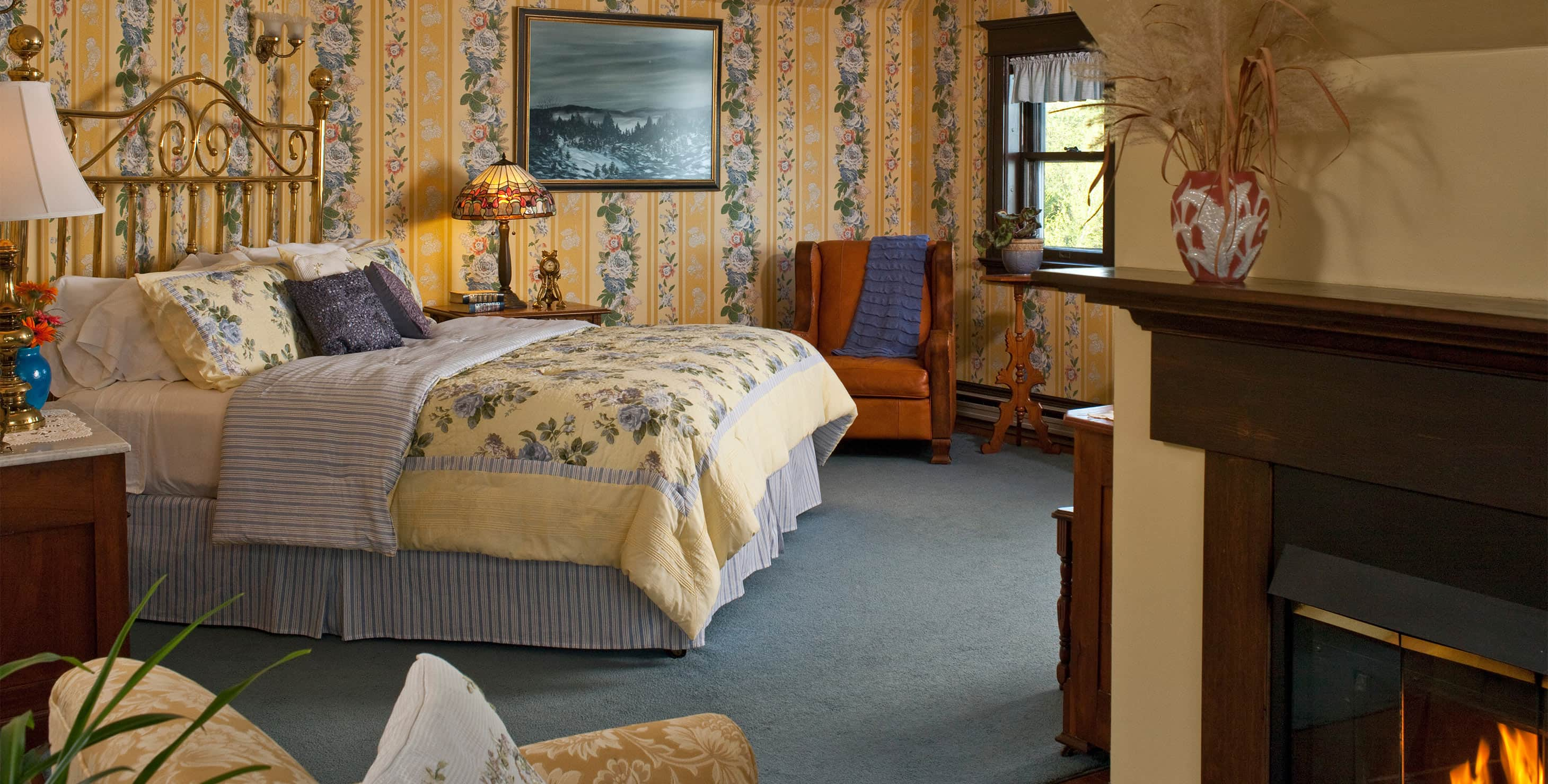 Bed, chair, fireplace and glimpse of couch in Turret Suite