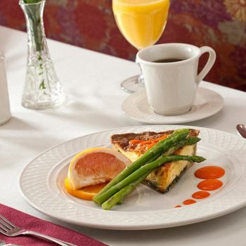 Plate with Quiche and Asparagus, coffee and juice in background.