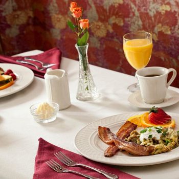 Breakfast Table with plates of food, coffee, orange juice, etc.