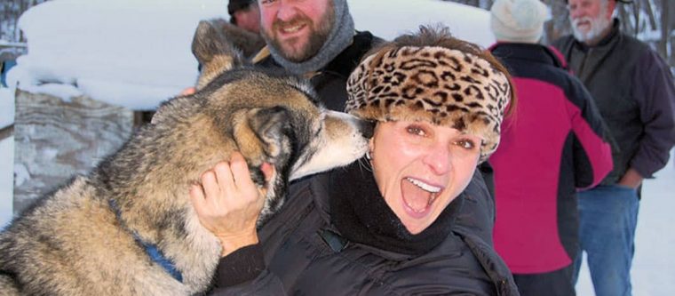 Woman getting a lick from a Sled Dog