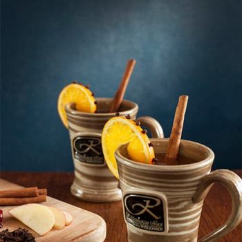 Hot drinks with cinnamon stick and lemon clove rind