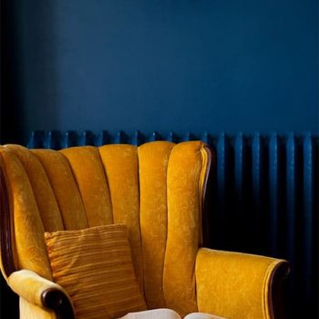 Yellow reading chair with an open book in Master Suite