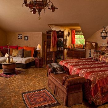 Bed, Window seat, sitting area, and fireplace in Moroccan Suite