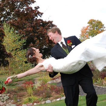Groom tossing bride in joy