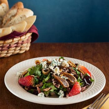 Fresh strawberry fig salad with blue cheese and bread in background