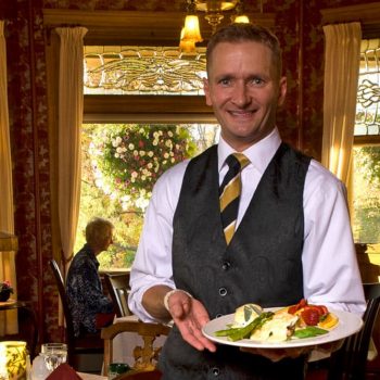 Waiter serving a plate of food in our dining room