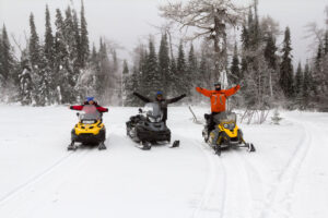 Group of three people riding the Wisconsin snowmobile trails near Bayfield